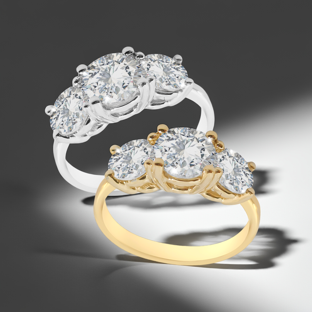 Two yellow and white gold trilogy ring on a dramatic white and black surface