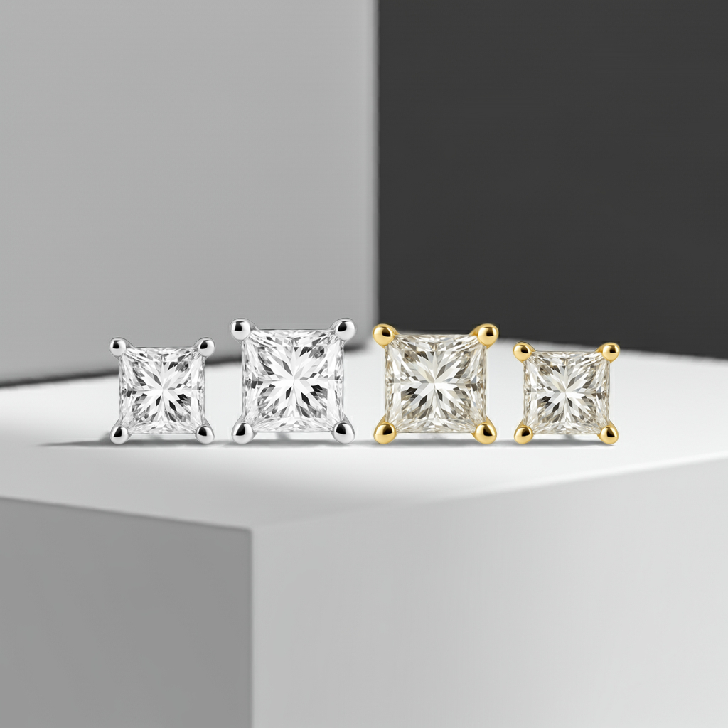 Pair of diamond stud earrings, one in white gold and one in yellow gold, on a white background.